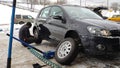 Winter tire fitting on the street. Wheel service, Tire repair, and changing summer to studded winter tires. Black car lifted on