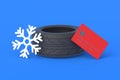 Winter tire near a credit card and snowflakes. The cost of replacing car wheels