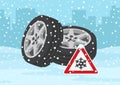 Winter tires and traffic sign warns of snow and ice. When to switch from summer tires. Perspective view.