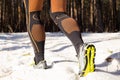 Winter trail running: man takes a run on a snowy mountain path in a pine woods. Royalty Free Stock Photo