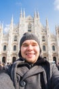 Winter travel, vacations and holidas concept - Young funny man taking selfie near Milan Cathedral Duomo di Milano, Italy