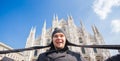 Winter travel, vacations and holidas concept - Young funny man taking selfie near Milan Cathedral Duomo di Milano, Italy