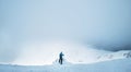 Winter Trekker staying on mountain peak he climbed and enjojing wide panorame view of valley covered by storm clouds. Active