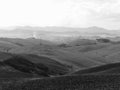 Winter Tuscany landscape with plowed fields at morning mist . Black and white photo