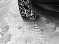 Winter tyre with tracks close up shot on the snow in black and white Royalty Free Stock Photo