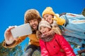 Winter vacation. Family time together outdoors taking selfie on smartphone grimacing to camera playful bottom view Royalty Free Stock Photo
