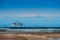 Winter view at the fishing boat in the sea with Mountains covered with snow Royalty Free Stock Photo