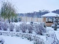 Winter view landscape design in a private yard. Cosy barbeque house / grill house.