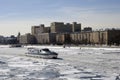 Winter view of the Moscow river embankment and cruise yacht sailing on iced water