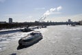 Winter view of the Moscow river embankment and cruise yacht sailing on iced water