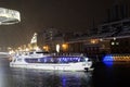 Winter view of the Moscow river embankment and cruise yacht sailing on iced water