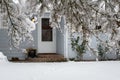 Winter view of a snow covered driveway and front of a light gray house Royalty Free Stock Photo
