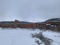 Winter view of the trail and firewood next to the old destroyed and abandoned factory Royalty Free Stock Photo