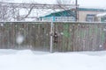 Winter in the village. Old dilapidated rickety fence of wooden boards. A lot of snow around Royalty Free Stock Photo