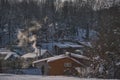 winter village scenery with smoke coming from house chimneys