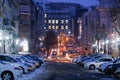 Cars drive along central snowy roads.