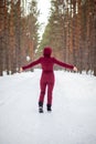 Winter walk in a snow-covered forest, A girl with a red jumpsuit Royalty Free Stock Photo