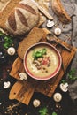 Winter warming soup. Mushroom cream soup with homemade rustic bread on a dark background. View from above,overhead