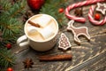 Winter warming sweet drink hot latte with marshmallows and cocoa in a mug with a Christmas holiday candy cane on a wooden backgrou Royalty Free Stock Photo