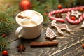 Winter warming sweet drink hot latte with marshmallows and cocoa in a mug with a Christmas holiday cinnamon on a wooden background
