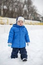 Winter warmly dressed boy walking on a snowy street