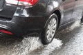 Winter weather in Israel: rain, puddles, floods and flooding. A car at high speed drives through a large puddle Royalty Free Stock Photo