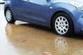 Car wheels in a puddle of rainwater, raindrops and water circles. Winter weather in Israel: rain, puddles, floods and flooding