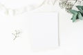 Winter wedding desktop stationery mockup. Blank greeting card, baby`s breath Gypsophila flowers, eucalyptus branch and