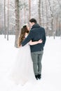 Winter wedding in the forest, bride and groom embracing, standing and looking each other Royalty Free Stock Photo