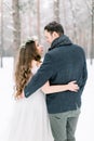 Winter wedding in the forest, bride and groom embracing, standing and looking each other Royalty Free Stock Photo