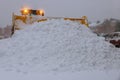 Wheel loader machine tractor removing snow. Clearing the road from ice and snow