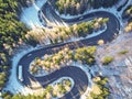 Winter winding road in the mountains with cars passing through Royalty Free Stock Photo