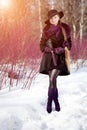 Winter woman on background of winter landscape, sun. Fashion girl in forest wonderland. Winter sunset scene. Model in sunlight, b