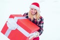 Winter woman with gift. Christmas Girl holding a big gift. Crazy Christmas girl pushes a big gift on snow winter Royalty Free Stock Photo