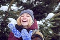 Winter woman with gift. Winter time. Happy cute girl in winter knitted hat sending blowing a kiss air. Outdoor shot of a Royalty Free Stock Photo