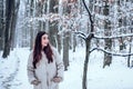 Winter woman. Portrait of a young woman in snow trying to warm herself. Beautiful girl in the winter forest in white Royalty Free Stock Photo