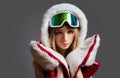 Winter woman with snow goggles posing at studio snowboard. Female snowboarder portrait.