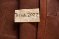 winter women's brown sheepskin coat as a background, natural winter coat and text on a piece of paper trends 2022 Royalty Free Stock Photo
