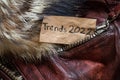 winter women's brown sheepskin coat as a background, natural winter coat and text on a piece of paper trends 2022 Royalty Free Stock Photo