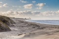 Winters dune and beach scenery along Dutch North Sea coast and blue sky with scatterd clouds Royalty Free Stock Photo