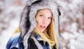 Wintertime. Closeup portrait girl in snow park. Beautiful young woman in warm coat and fur hat. Season of winter. Royalty Free Stock Photo