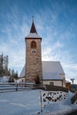 A wintertime view of a small church with a tall steeple Royalty Free Stock Photo