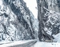 Wintery snowcovered mountain road with white snowy spruces and rocks. Wonderful wintry landscape. Travel background.