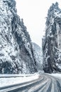 Wintery snowcovered mountain road with white snowy spruces and rocks. Wonderful wintry landscape. Travel background. Royalty Free Stock Photo
