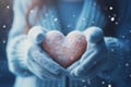 Wintry love symbol: Female hands, gloves, snowy heart, Valentines concept