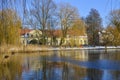 A wintry scene in Berlin, Germany, district Lichtenrade, with a village pond in the foreground and a small manor in the background