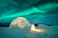 Wintry scene with glowing polar lights and snowy igloo Royalty Free Stock Photo