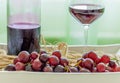 Winw bottle, glass of red wine and grapes on a rustic plate Royalty Free Stock Photo