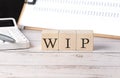 WIP word on a wooden block with clipboard and calcuator Royalty Free Stock Photo