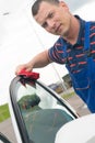 Worker, wipes the car door with a red rag Royalty Free Stock Photo